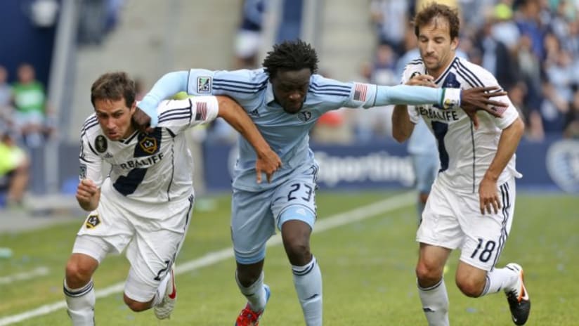 LA Galaxy's Mike Magee and Todd Dunivant battle for the ball with Sporting KC's Kei Kamara