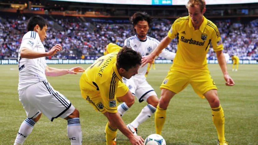 Columbus Crew's Danny O'Rourke and Josh Williams are swamped by Vancouver Whitecaps Daigo Kobayashi and YP Lee.