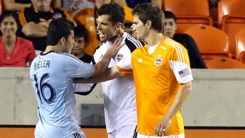 Tally Hall and Bobby Boswell of the Houston Dynamo argue with Sporting KC striker Claudio Bieler