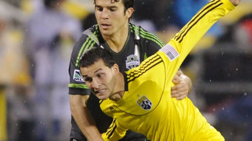 Columbus' Dilly Duka is held up by Seattle's Servando Carrasco.