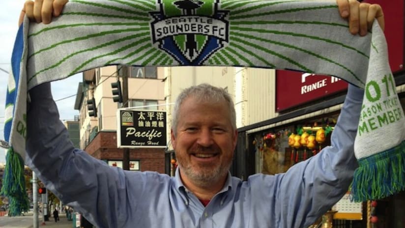 Mayor of Seattle holds Sounders scarf following bet with mayor of Portland