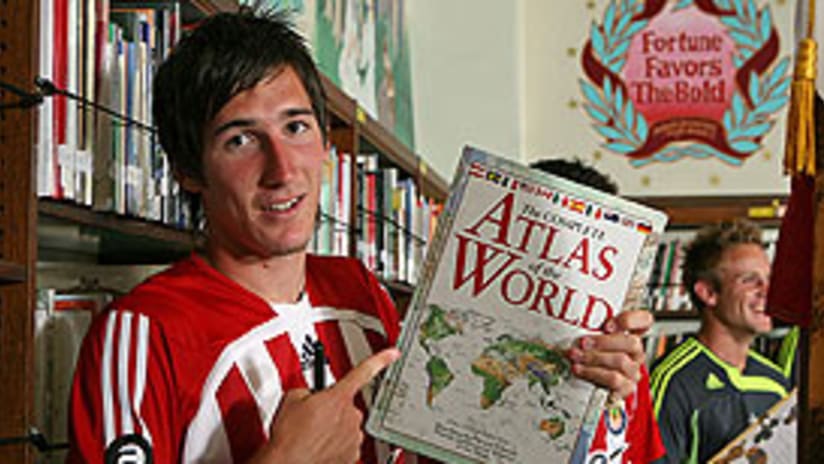 Sacha Kljestan does a little reading while waiting to take the team photo.