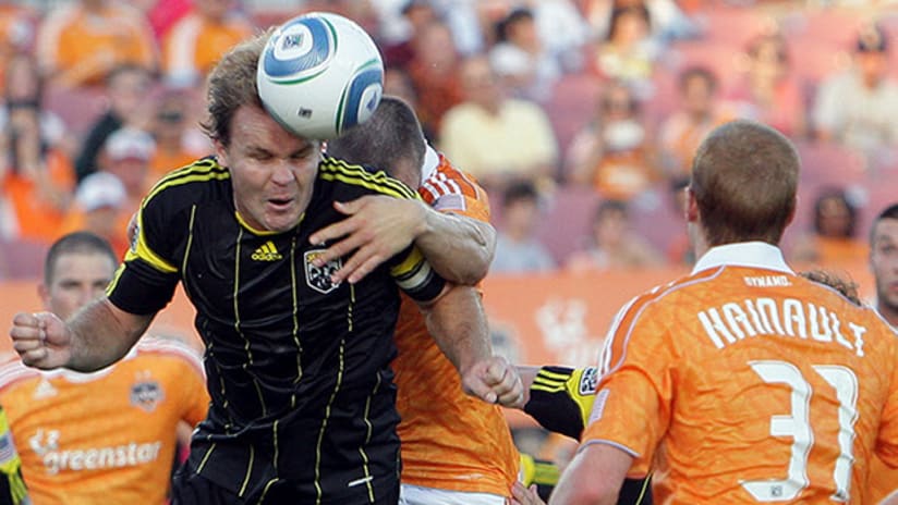 Chad Marshall of the Columbus Crew heads a ball away from a Houston Dynamo scrum.