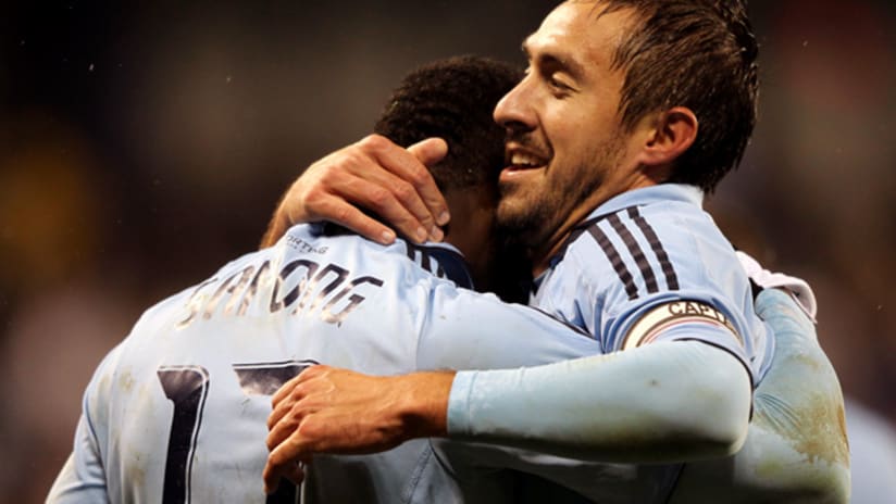 Sporting KC's Davy Arnaud (right) embraces teammate CJ Sapong