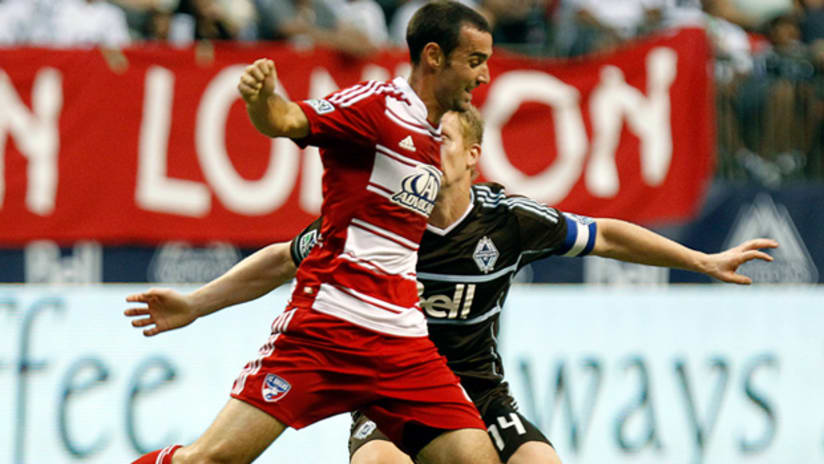 FCD's Andrew Jacobson dribbles by Vancouver's Barry Robson