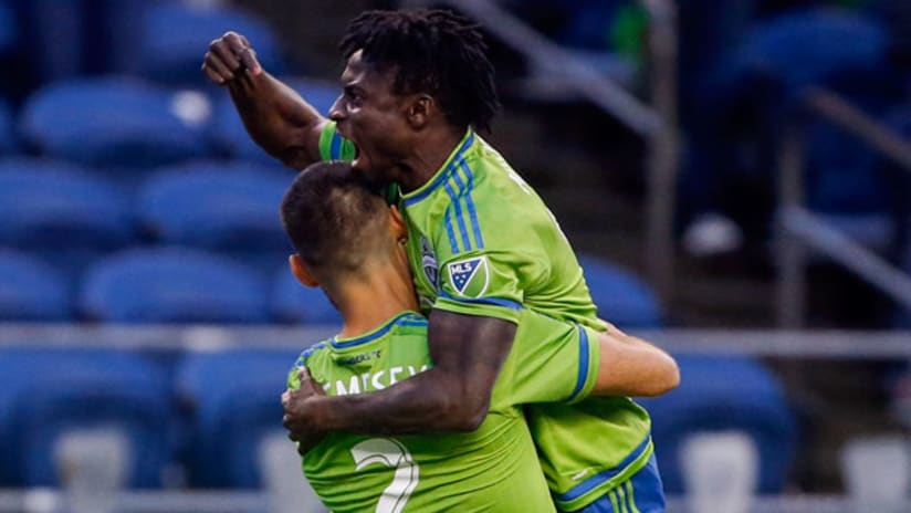 Seattle Sounders FC forward Obafemi Martins jumps into the arms of forward Clint Dempsey