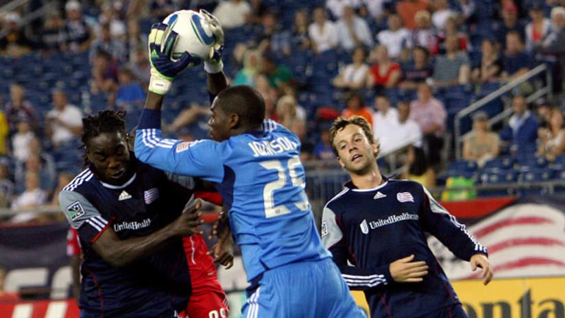Sean Johnson of the Chicago Fire interrupts the New England Revolution attack led by Shalrie Jospeh and Zack Schilawski.