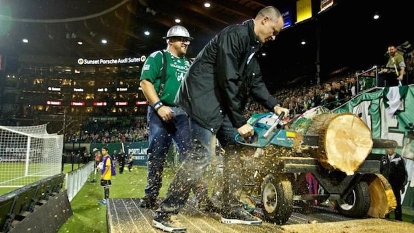 Portland Timbers owner Merritt Paulson cuts a slab from log during 6-0 CCL win