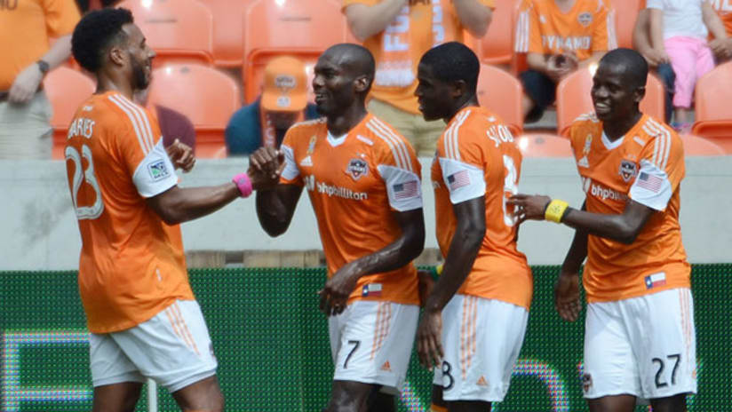 Houston Dynamo players celebrate a goal by Omar Cummings