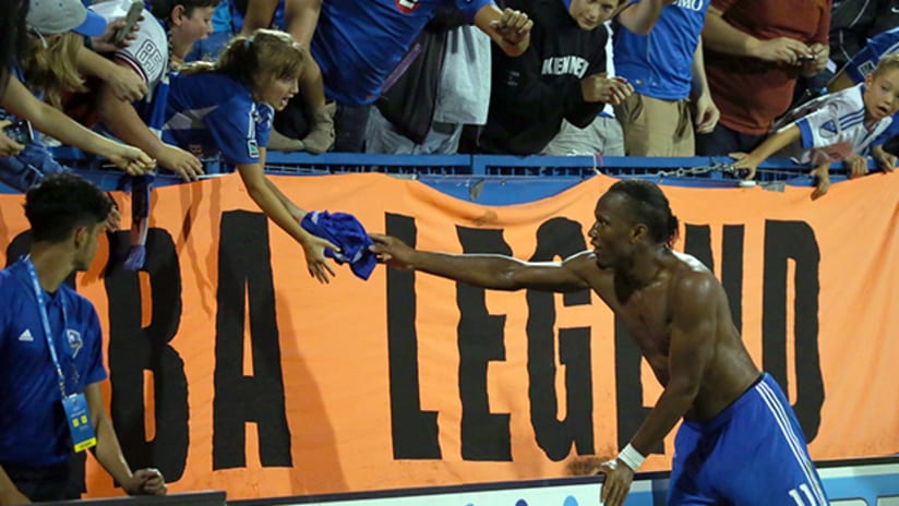 Didier Drogba hands his Montreal Impact jersey to a fan