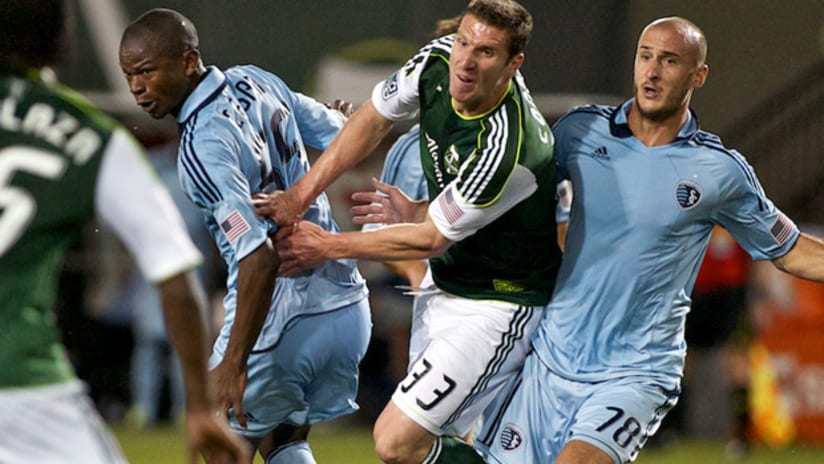 Sporting KC's Julio Cesar (left) and Aurellien Collin (right) stop Portland's Kenny Cooper.