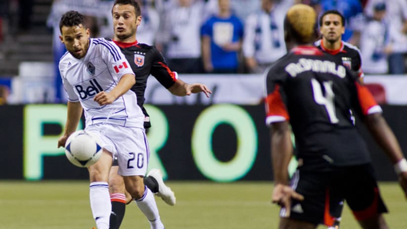 Vancouver's Davide Chiumiento controls the ball as he's surrounded by D.C. United players