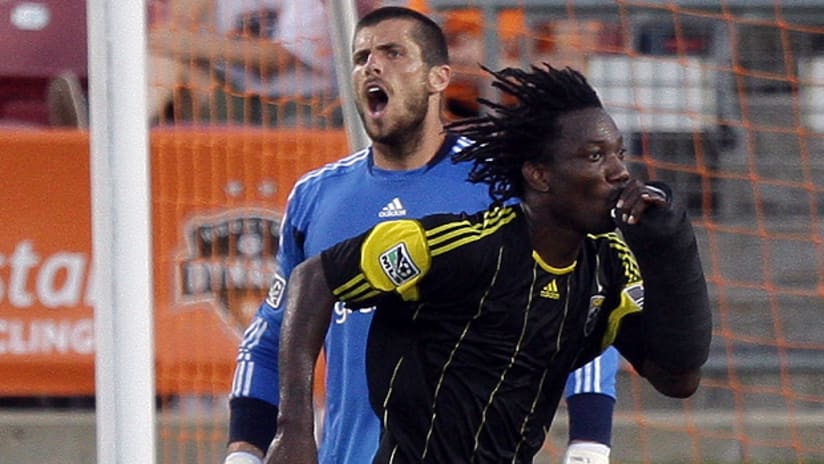 Tally Hall of the Houston Dynamo shouts at a sprinting Andres Mendoza of the Columbus Crew.