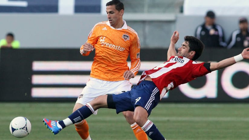 Houston's Geoff Cameron upends Chivas USA's Juan Pablo Angel and gains control of the ball, March 11, 2012.