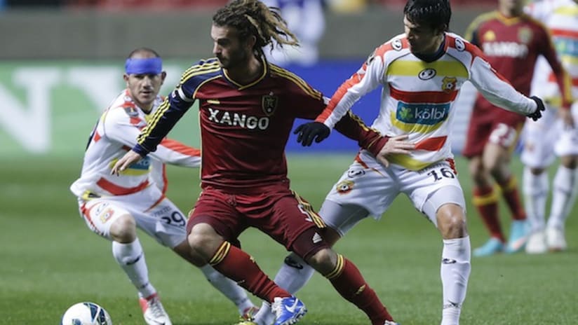 Kyle Beckerman battles two Herediano players for the ball