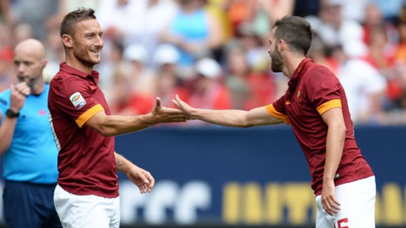 Francesco Totti and Miralem Pjanic celebrate a goal vs. Manchester United