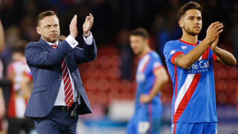 Doncaster Rovers manager Paul Dickov and a player applaud the fans