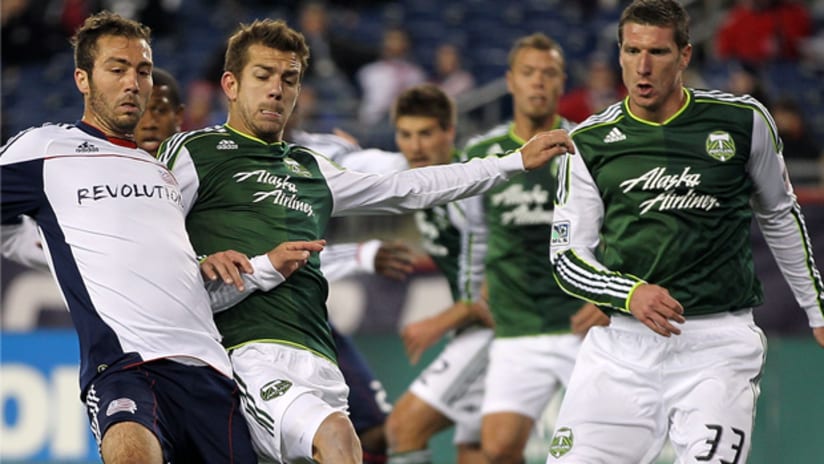 Portland's Eric Brunner defends vs. New England AJ Soares as teammate Kenny Cooper watches on.
