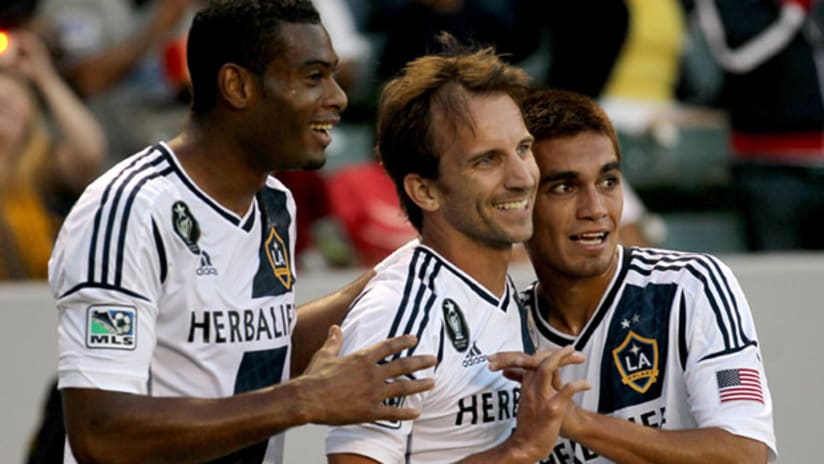 LA Galaxy's David Junior Lopes, Mike Magee, and Hector Jimenez celebrate a goal.