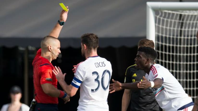 Referee Chris Penso gives Jason Johnson (Chicago Fire) a yellow card