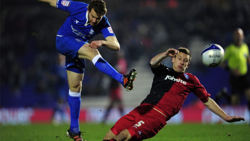 Birmingham City's Johnathan Spector unload a cross as Portsmouth's Jason Pearce slides in