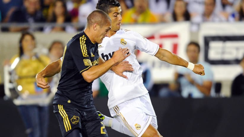 Real Madrid's Cristiano Ronaldo (right) runs by LA Galaxy's Bryan Jordan