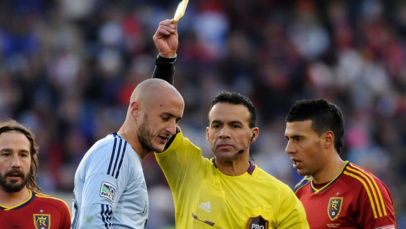 Aurelien Collin receives a yellow card during MLS Cup 2013
