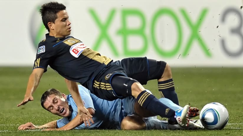 Philadelphia's Roger Torres collides with Sporting's Matt Besler during a match on June 22.
