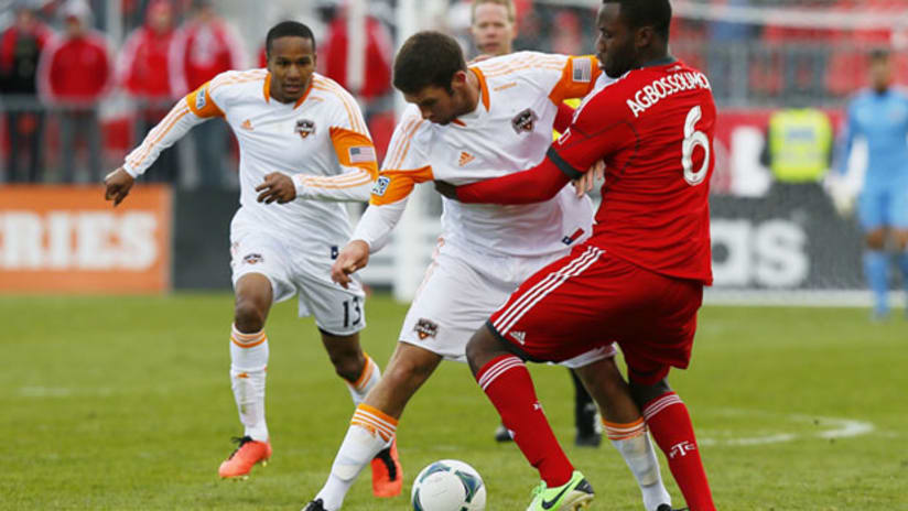 Houston Dynamo's Will Bruin battles Toronto FC's Gale Agbossoumonde.