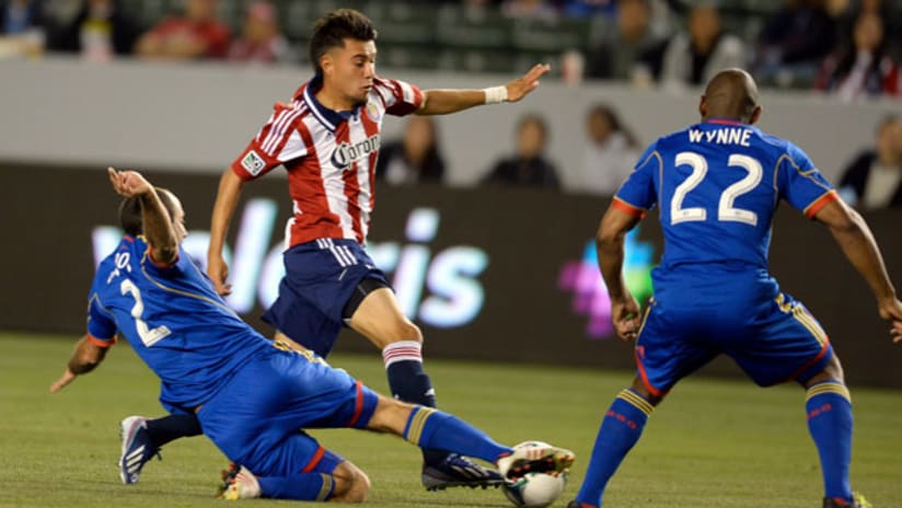 Chivas USA's Carlos Alvarez evades a tackle from Colorado's Nick LaBrocca while Marvell Wynne watches