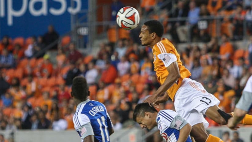 Houston Dynamo midfielder Ricardo Clark jumps over Mauro Diaz