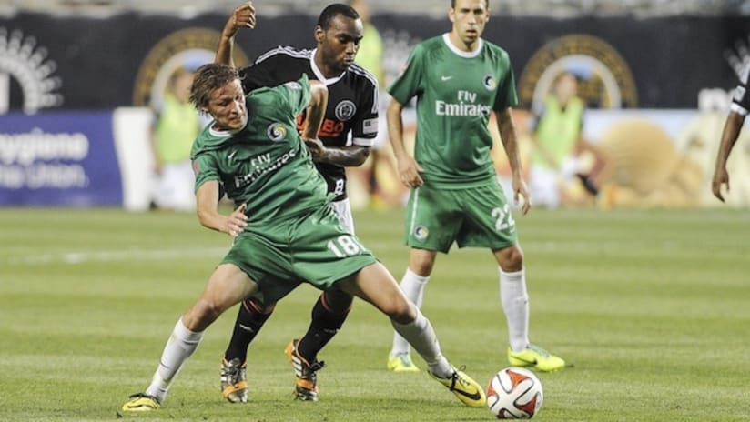Amobi Okugo battles a New York Cosmos player for the ball in the Open Cup