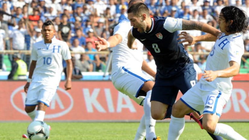 Clint Dempsey works past Roger Espinoza in the Honduras-USA match