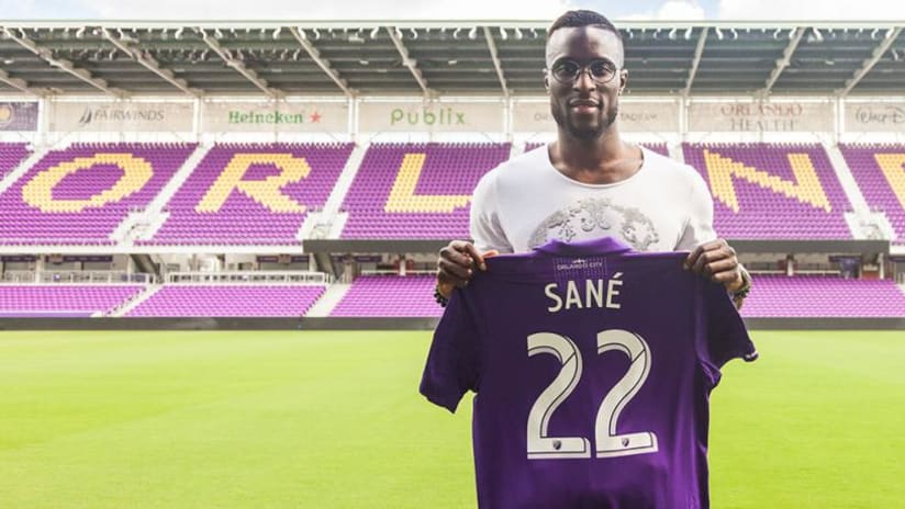 Lamine Sané holding an Orlando City jersey after being signed — 2/20/18