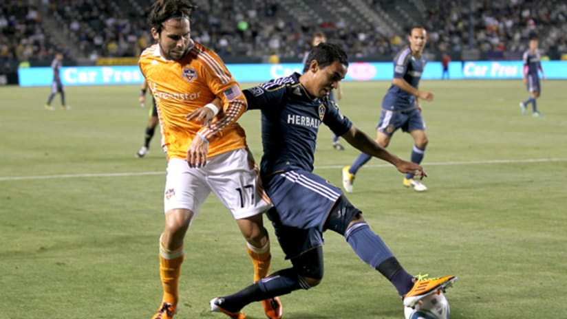 Miguel Lopez of the Los Angeles Galaxy battles for the ball against Mike Chabala of the Houston Dynamo at The Home Depot Center on May 25, 2011.