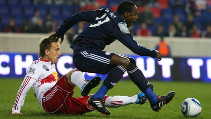 New England's Tony Tchani gets tripped up by New York's Brian Nielsen on Wednesday night at Red Bull Arena.