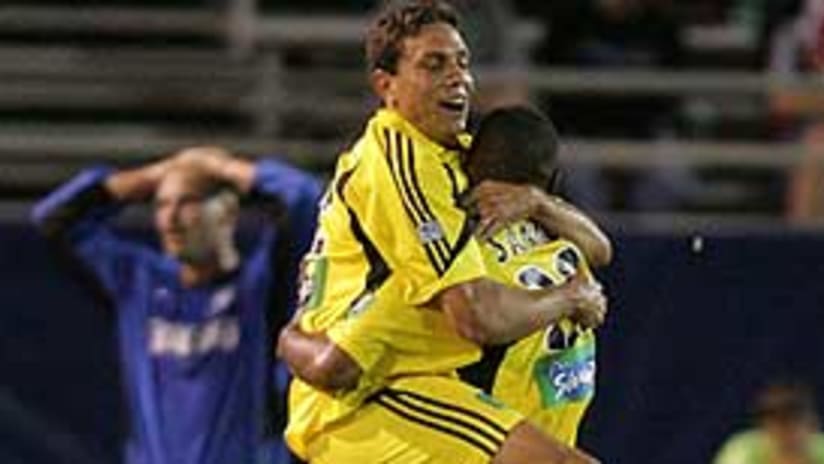 Manny Lagos and Tony Sanneh celebrate Sanneh's last-gasp game clincher.
