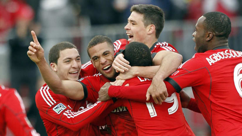 Toronto's Darel Russell is mobbed by teammates after his stoppage-time equalizer vs. Dallas