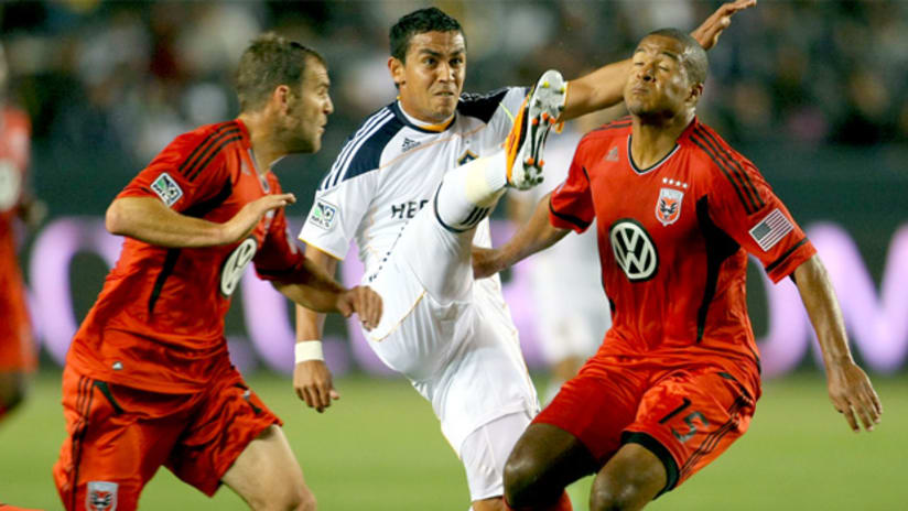 Galaxy's Miguel Lopez plays the ball between DC's Daniel Woolard (left) and Ethan White.