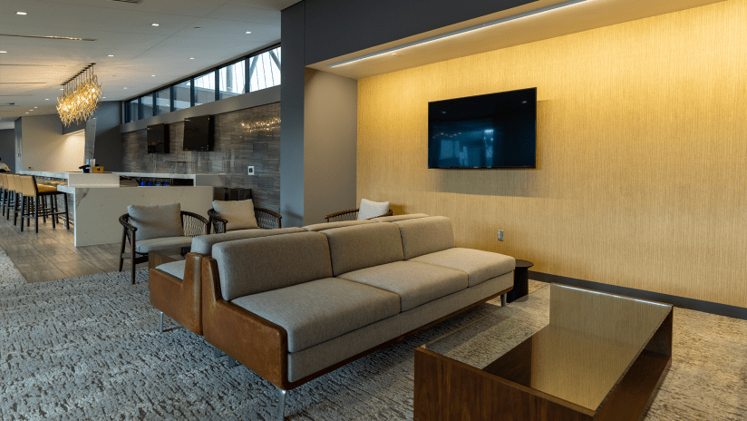 Lounge area with tvs and couches for fans with a suite
