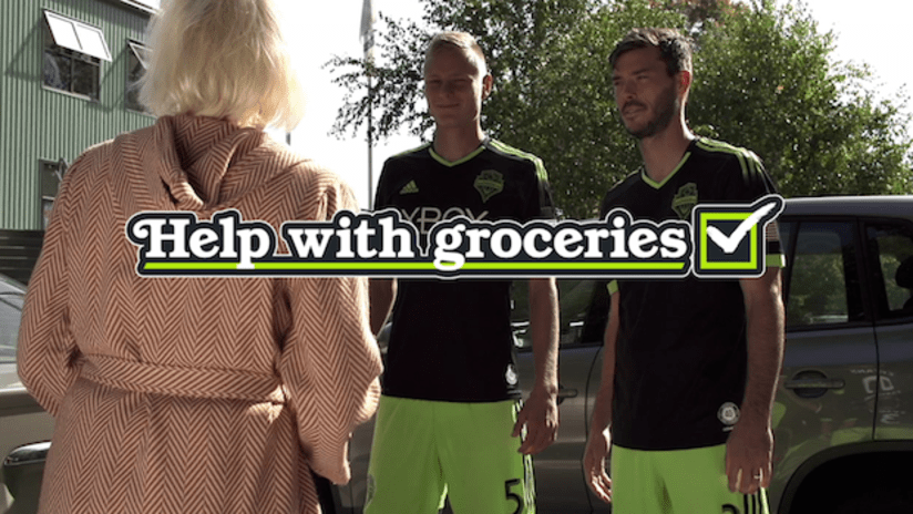 Brad Evans and Andy Rose carry groceries for a lady