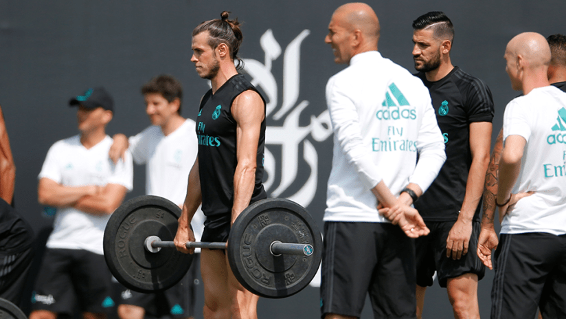 Real Madrid - Zinedine Zidane - looks on as - Gareth Bale - lifts weights