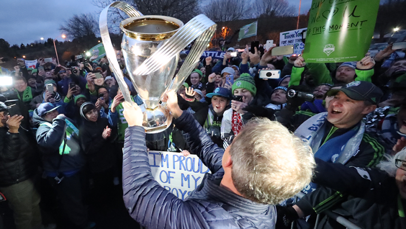 Brian Schmetzer - Seattle Sounders - hoists MLS Cup before crowd at airport - Dec. 11, 2016