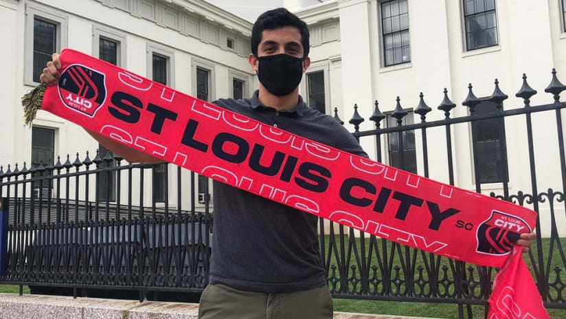 A St. Louis City SC fan holds up a scarf before the first game for the