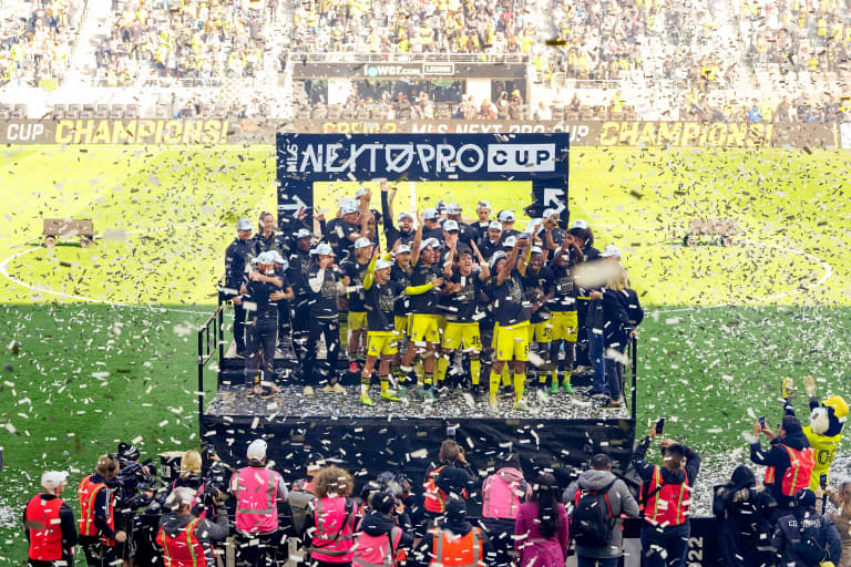 Crew 2 players and head coach Laurent Courtois celebrate with the trophy after winning the MLS NEXT Pro Cup