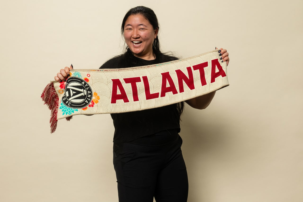 Atlanta United staff member models May Scarf of the Month on Tuesday, April 25, 2023.