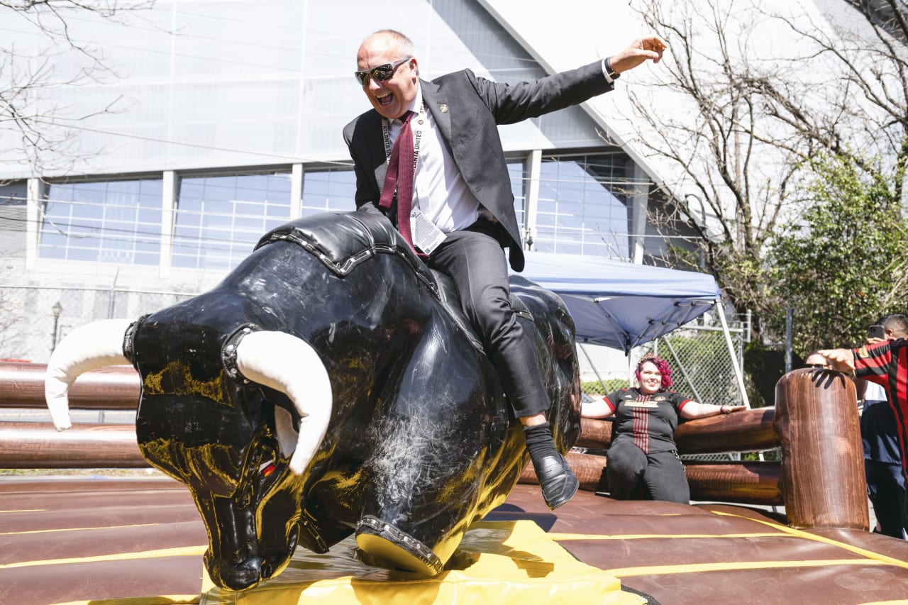 Atlanta United President Darren Eales rides a bull at the supporters tailgate before the match against CF Montreal at Mercedes-Benz Stadium in Atlanta, United States on Saturday March 19, 2022. (Photo by Adam Hagy/Atlanta United)