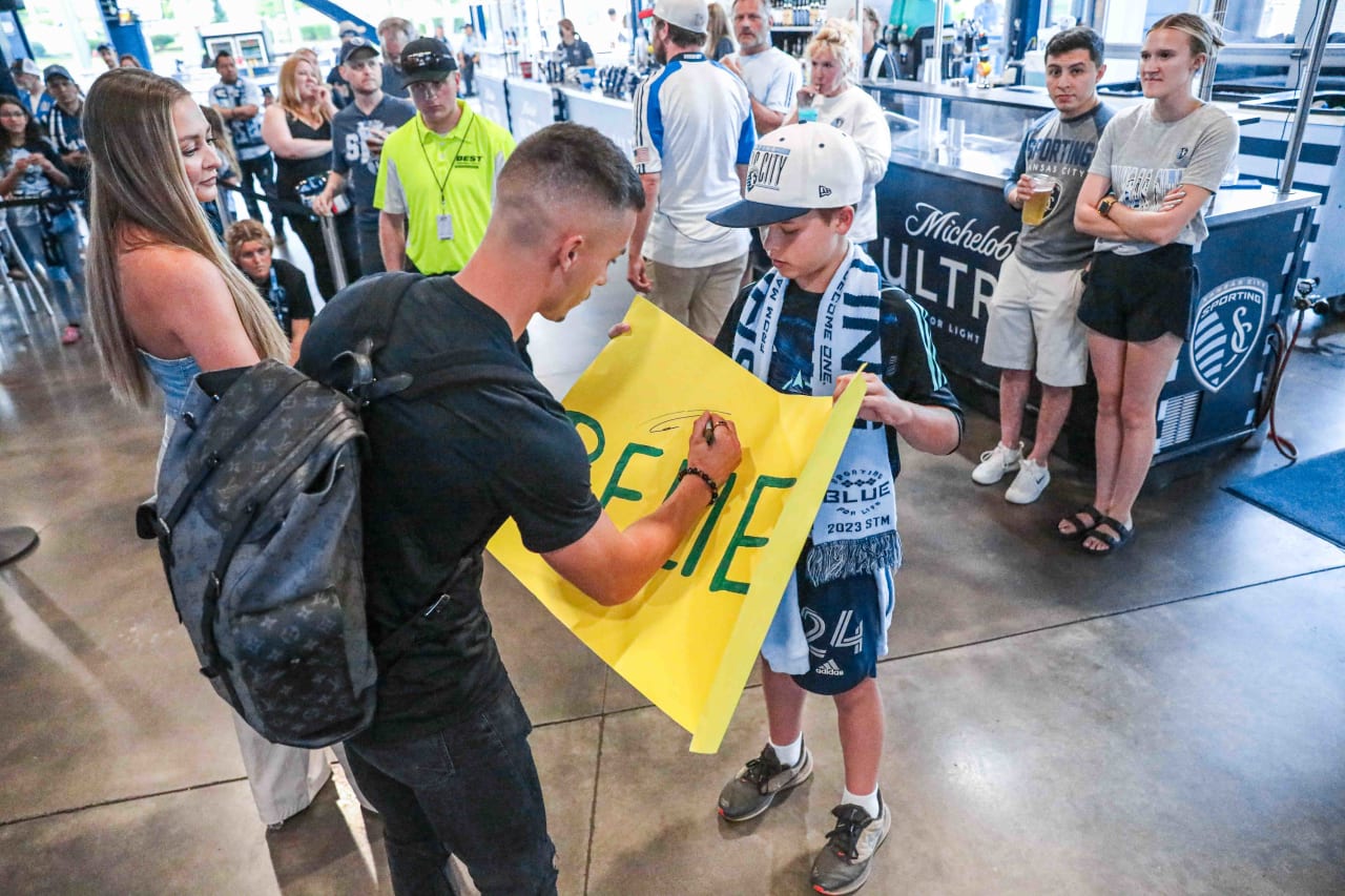 Midfielder, Erik Thommy signs a BELIEVE poster for a young fan before the May 31 match.
