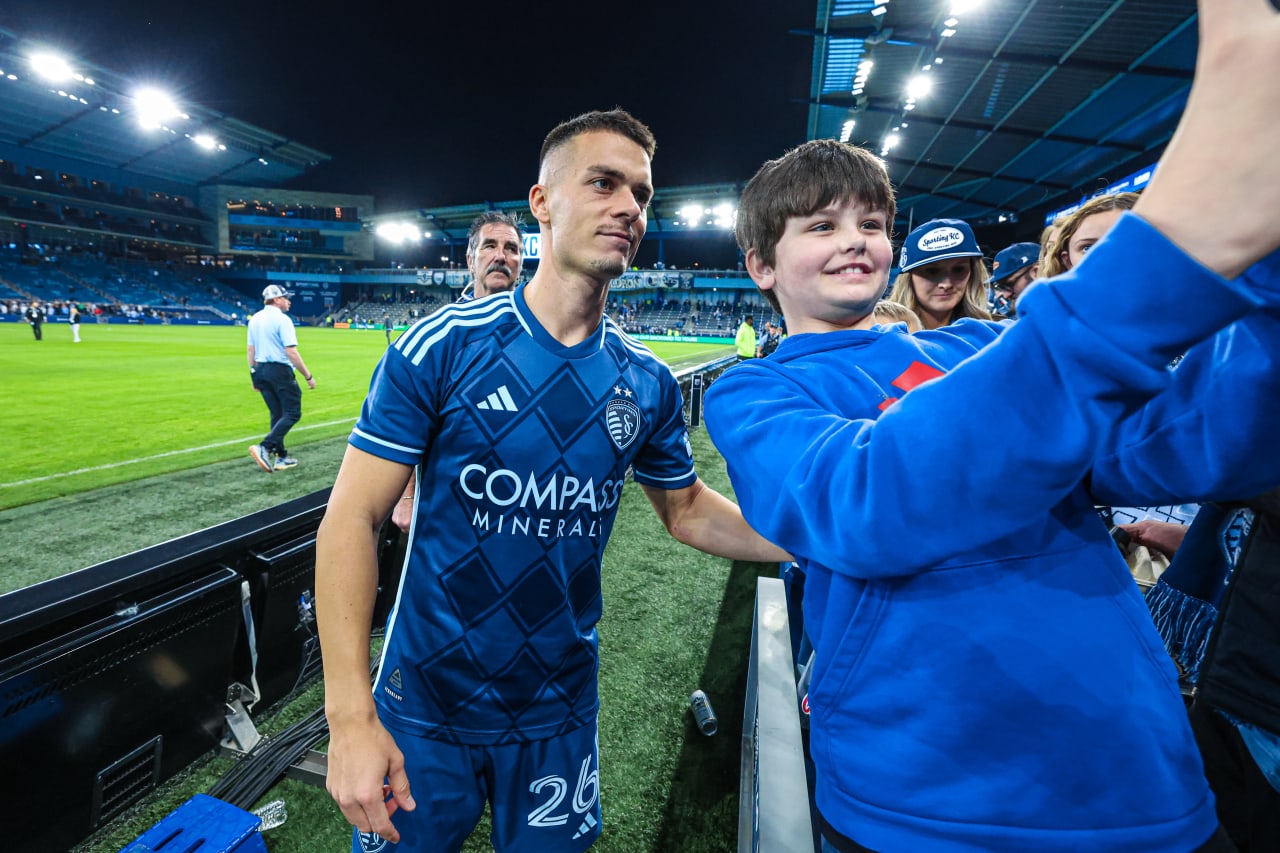 Midfielder Erik Thommy takes a photo with a young fan post-match.