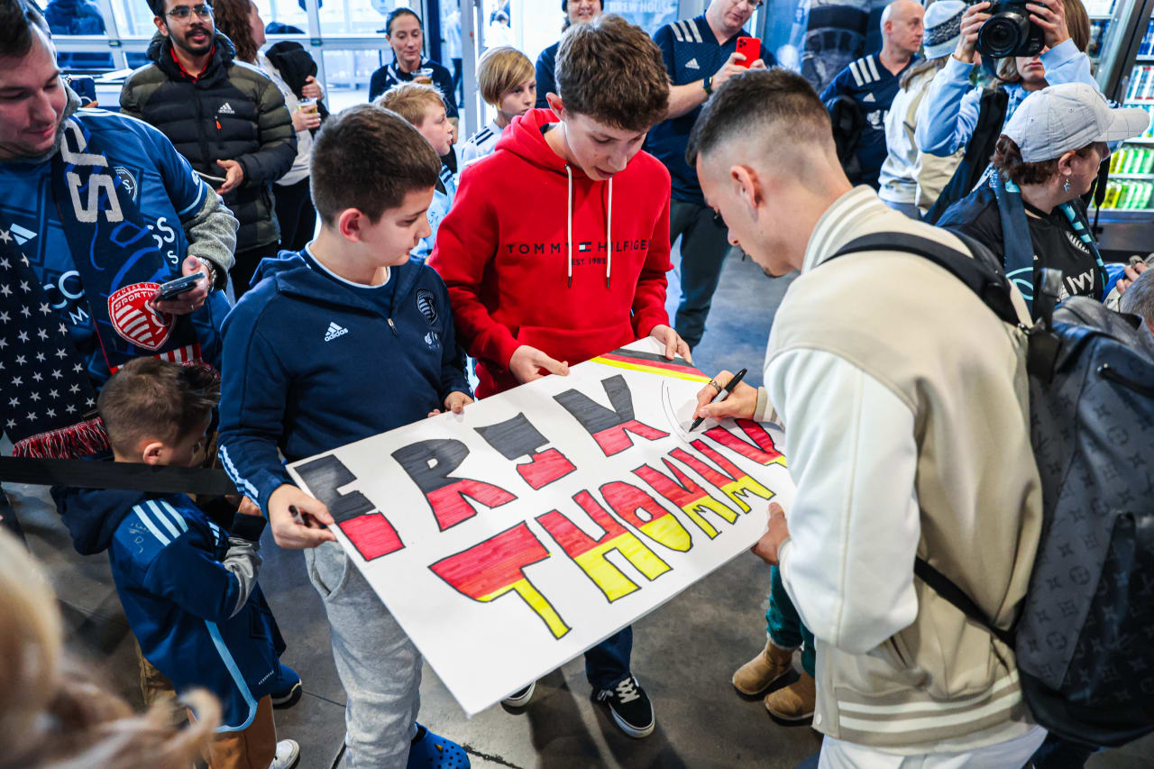 Midfielder Erik Thommy signs a card made by fans ahead of th ematch.